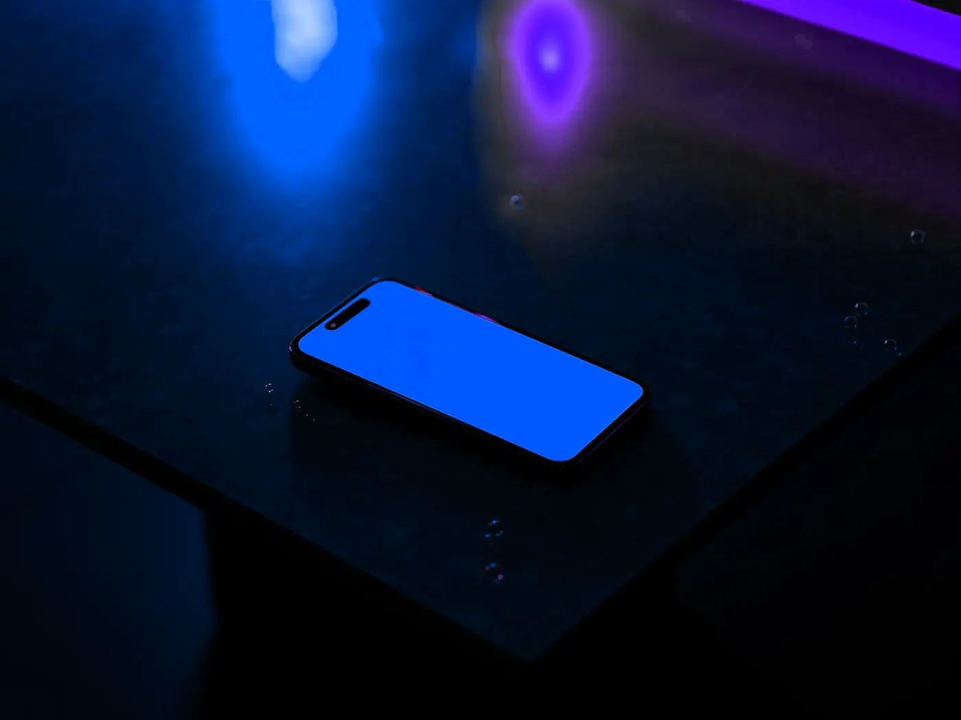 Celular sobre una mesa iluminado en azul: chatbot de WhatsApp con IA